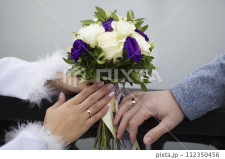 Bridal bouquet and hands with wedding rings. The bride's bouquet. Wedding rings. Bridal bouquet and hands with wedding rings. The bride's bouquet. Wedding rings. 112350456