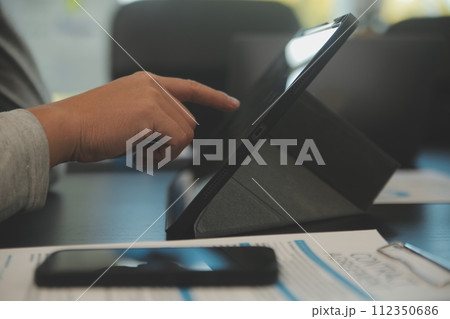 Laptop on a desk in an open financial office. 112350686