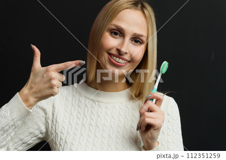 Young beautiful woman points her finger at the toothbrush. 112351259