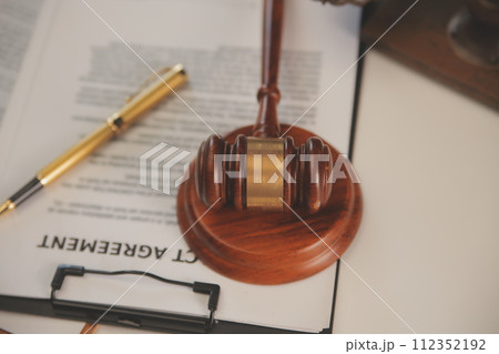 image of judge's hammer, scales lady of justice, law book, laptop computer and contract documents with pen concept of law and justice. image of judge's hammer, scales lady of justice, law book, laptop computer and contract documents with pen concept of law and justice. 112352192
