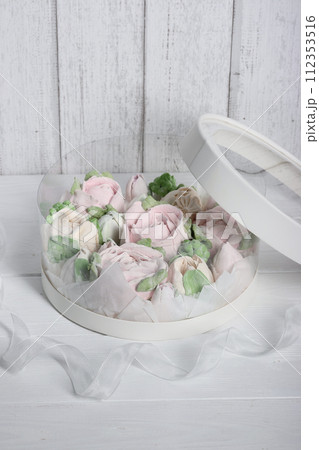 Marshmallows in hatboxes. Marshmallow flowers. Homemade marshmallows. A white hatbox. There is a packing tape next to it. 112353516