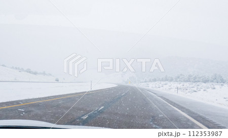 POV-Electric vehicle is captured deftly navigating the I-70 highway during a winter storm in Western Colorado. 112353987