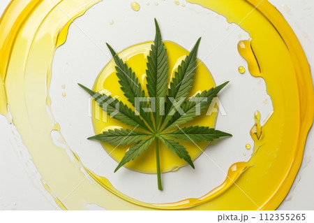 Idealistic cannabis leaf on white background in smooth neat circle of yellow hemp oil, minimalist, aesthetic, simple. Top view. Medicinal marijuana in beauty industry. CBD, CBN oil concept 112355265