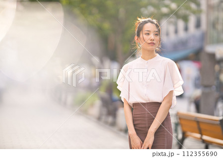 夕暮れの街でショッピングを楽しむ若い女性 112355690