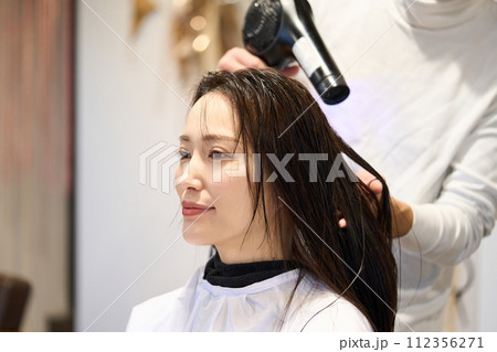 ヘアサロンで髪を乾かす女性 112356271