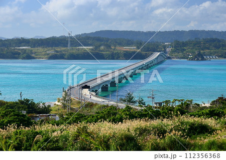 沖縄県国頭郡今帰仁村　古宇利島から屋我地島にかかる古宇利大橋と古宇利ブルーの海を高台から望む 112356368