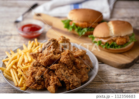 fried chicken, chicken sandwich and fries 112356683