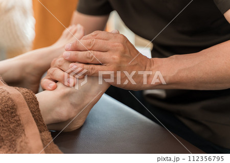 リフレクソロジー・足つぼマッサージ・整体院・マッサージに通う女性と整体師・マッサージ師・セラピスト 112356795