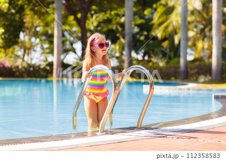 Child in swimming pool with ball. Kids swim. Child in swimming pool with ball. Kids swim. 112358583