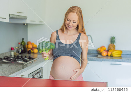 Embracing a nutrient-rich choice, a pregnant woman eagerly prepares to enjoy a wholesome serving of broccoli, prioritizing healthy and nourishing options during her pregnancy 112360436