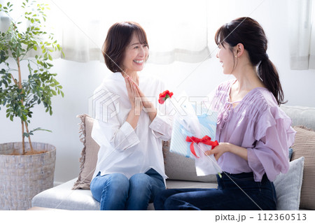 母の日　カーネションとプレゼントをもらうお母さん 112360513