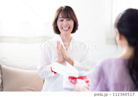 母の日 カーネションとプレゼントをもらうお母さん 母の日 カーネションとプレゼントをもらうお母さん 112360517