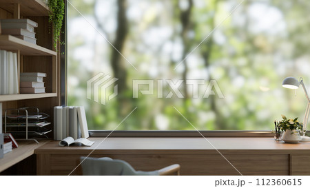 A presentation space on a wooden desk against the window in a cozy, contemporary home office room. A presentation space on a wooden desk against the window in a cozy, contemporary home office room. 112360615