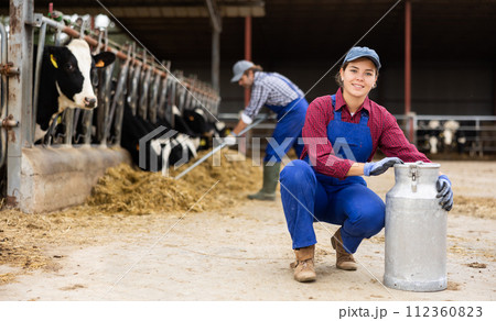 Farmer woman is holding can at cow farm Farmer woman is holding can at cow farm 112360823