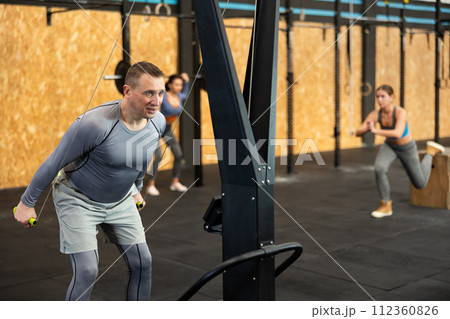 Adult man training with straps in gym 112360826