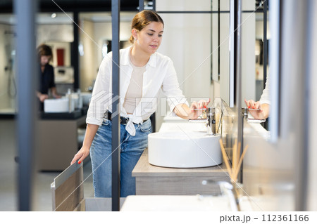 Woman looking to buy new bathroom sink in harware store Woman looking to buy new bathroom sink in harware store 112361166
