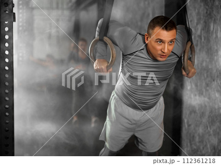 Adult man training on gymnastic rings Adult man training on gymnastic rings 112361218
