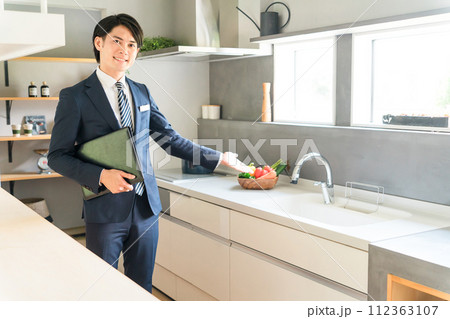 システムキッチンのおすすめをするハウスメーカーのプランナー・アドバイザー・コーディネーターの男性 システムキッチンのおすすめをするハウスメーカーのプランナー・アドバイザー・コーディネーターの男性 112363107