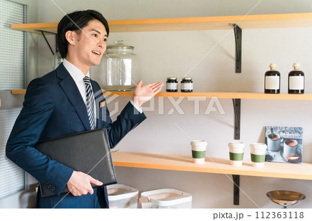 モデルハウスでパントリーの説明・案内をしているハウスメーカーの男性営業マン 112363118