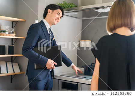 IH調理器・IHクッキングヒーター・ IH・電磁調理器を案内するハウスメーカーのプランナーの男性 112363260