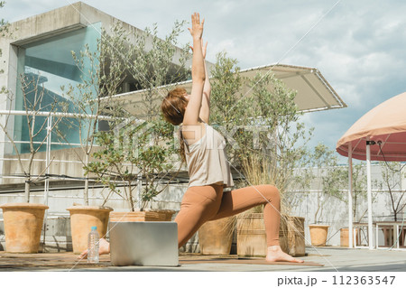 太陽礼拝・オンラインヨガ・リモートヨガをするヨガ講師の女性・ヨガインストラクター 112363547