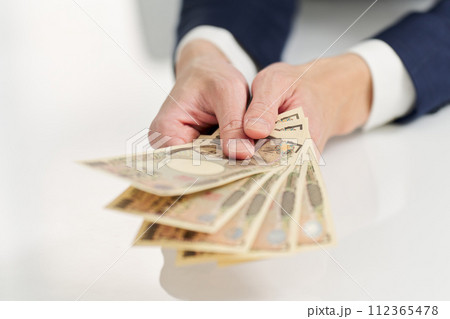 お金を支払うビジネスマンの手元 112365478