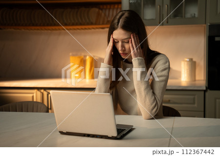 Young Woman Overwhelmed by Emotion While Working on Laptop at Home 112367442