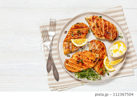 juicy grilled chicken cutlets on plate, top view juicy grilled chicken cutlets on plate, top view 112367504