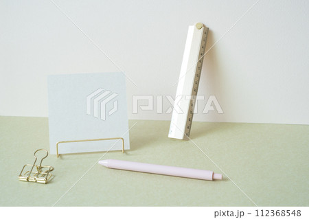Blank memopad with gold metallic holder, ruler, pen, clip on desk. white ivory background. workspace office stationery Blank memopad with gold metallic holder, ruler, pen, clip on desk. white ivory background. workspace office stationery 112368548