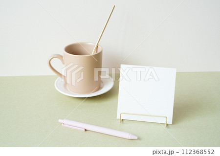 Blank memopad with holder, pen, mug cup on desk. white ivory background. workspace office stationery 112368552