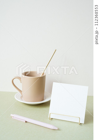 Blank memopad with holder, pen, mug cup on desk. white ivory background. workspace office stationery 112368553