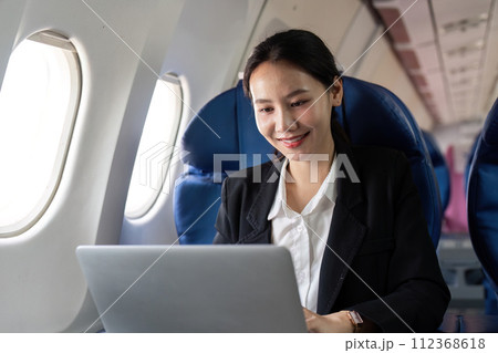 Asian young woman using laptop at first class on airplane during flight, Traveling and Business concept 112368618