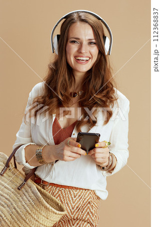 happy woman listening to music isolated on beige 112368837
