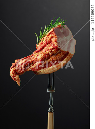 Smoked pork with rosemary on a fork. Smoked pork with rosemary on a fork. 112369082