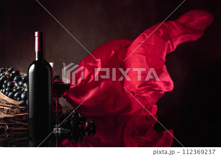 Red wine with grapes on a background of red flutters curtain. 112369237