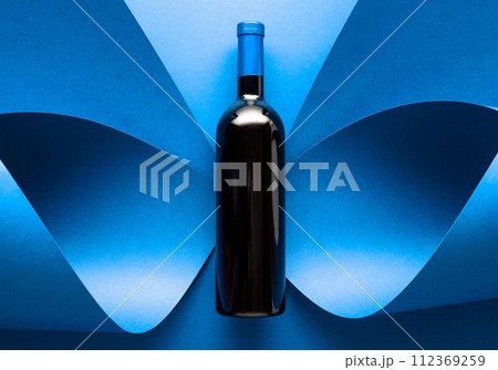 Bottle of red wine on a blue background. Bottle of red wine on a blue background. 112369259