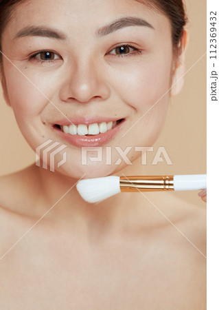 Portrait of modern asian woman with makeup brush Portrait of modern asian woman with makeup brush 112369432