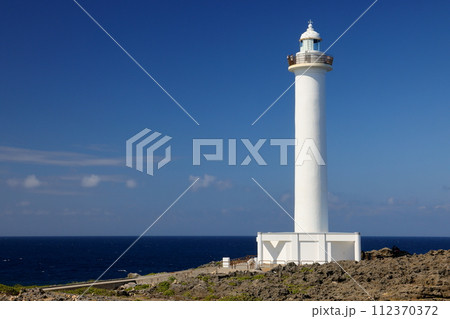 沖縄県中頭郡読谷村宇座　残波岬突端に建つ白亜の残波岬灯台と断崖の下の青い海 112370372