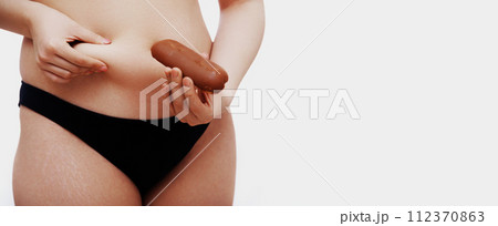 Overweight female body. Beautiful woman holding Overweight female body. Beautiful woman holding 112370863