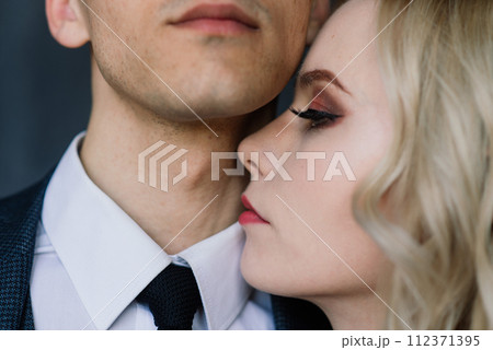 Cute wedding couple in the interior of a classic studio decorated. They kiss and hug each other. 112371395