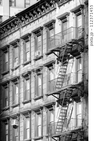 Black and white photo of old building with fire escape, New York City, USA. 112371455