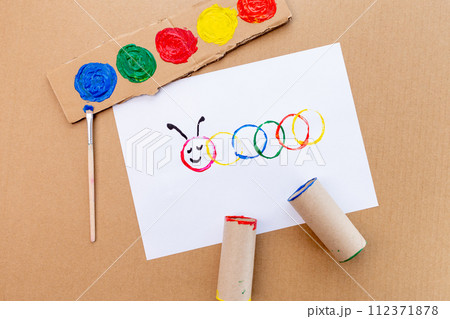 a piece of paper sitting on top of a table, a child's drawing, action painting, the caterpillar, circle, made of cardboard, having a good time a piece of paper sitting on top of a table, a child's drawing, action painting, the caterpillar, circle, made of cardboard, having a good time 112371878