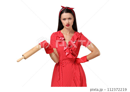 Housewife girl with kitchen utensils in her hands, on a gray background. 112372219