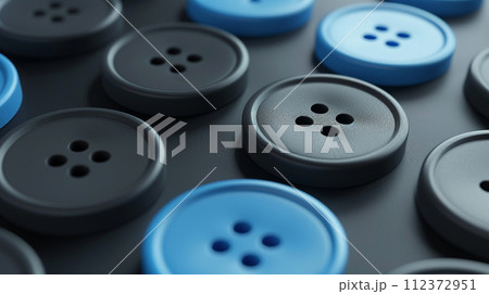 An array of blue and black sewing buttons scattered across a dark surface, showcasing a simple yet elegant design concept. 112372951