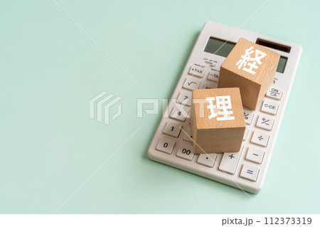 経理の文字が入ったブロックと電卓 経理の文字が入ったブロックと電卓 112373319