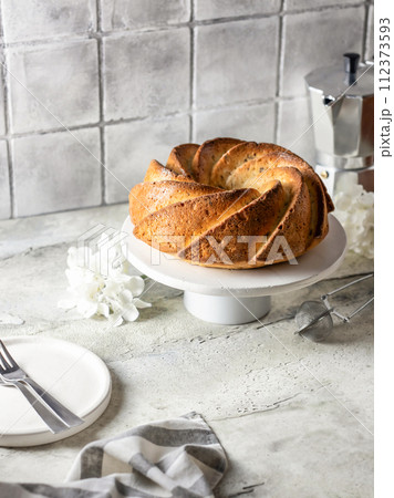 Homemade bundt cake in composition for morning cozy breakfast. Gray tile kitchen background 112373593