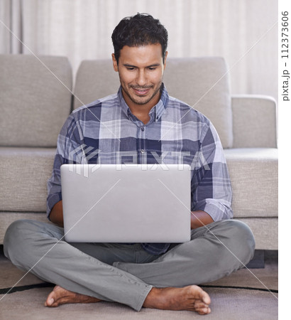 Man, student and internet for laptop on floor of living room, education and scroll or browse on website. Male person, happy and online for information or home for app, sitting and elearning on tech 112373606