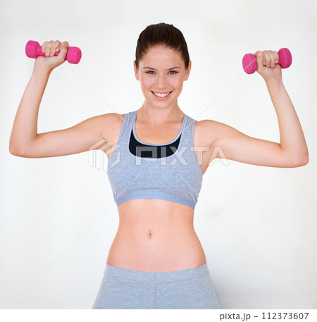 Woman, flexing or portrait with dumbbells in studio, wellness or fitness for weight loss with exercise. Young person, strong pose and face with hand weights for muscle training and white background 112373607