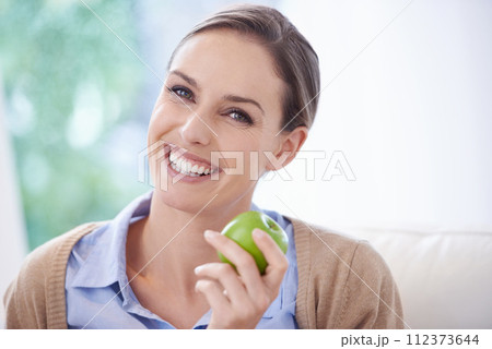 Portrait, home or happy woman with apple for healthy or balanced diet with nutrition, smile or vitamins. Face, relax and vegan person eating fresh fruit, food or fibre for organic wellness in lounge Portrait, home or happy woman with apple for healthy or balanced diet with nutrition, smile or vitamins. Face, relax and vegan person eating fresh fruit, food or fibre for organic wellness in lounge 112373644