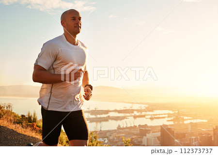 Fitness, running and man on hill at sunset for health, wellness and strong body development. Workout, exercise and runner on path in nature for marathon training, performance and outdoor challenge. 112373737